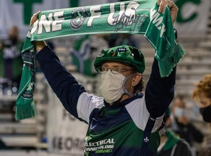 A St. Louis City SC fan holds up a scarf before the first game for the